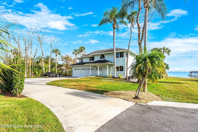 100 Bonita St, Titusville, FL 32780 - traditional-style home with concrete driveway, a front yard, a water view, and stucco siding