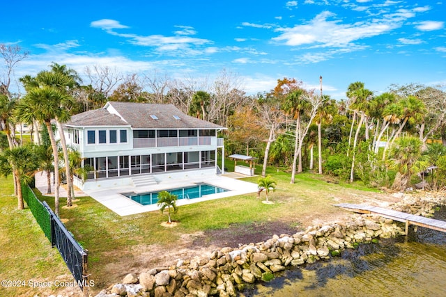 100 Bonita St, Titusville, FL 32780 - rear view of house with a sunroom, a patio, an outdoor pool, and roof with shingles