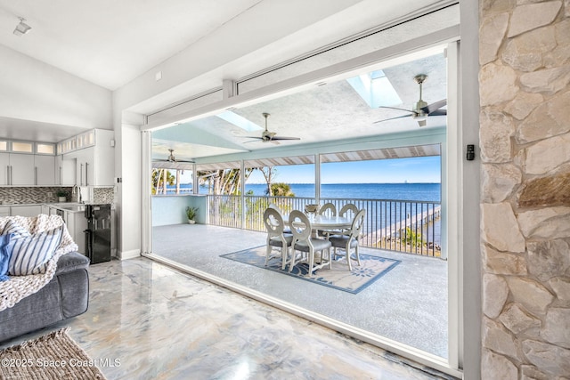 100 Bonita St, Titusville, FL 32780 - dining space with a ceiling fan, a water view, a skylight, vaulted ceiling, and marble finish flooring