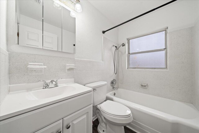 full bathroom featuring vanity, toilet, tile walls, and tiled shower / bath combo