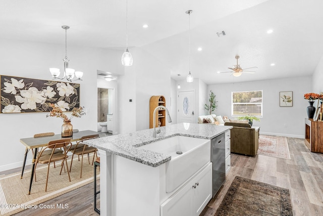 kitchen with dishwasher, sink, white cabinets, pendant lighting, and an island with sink