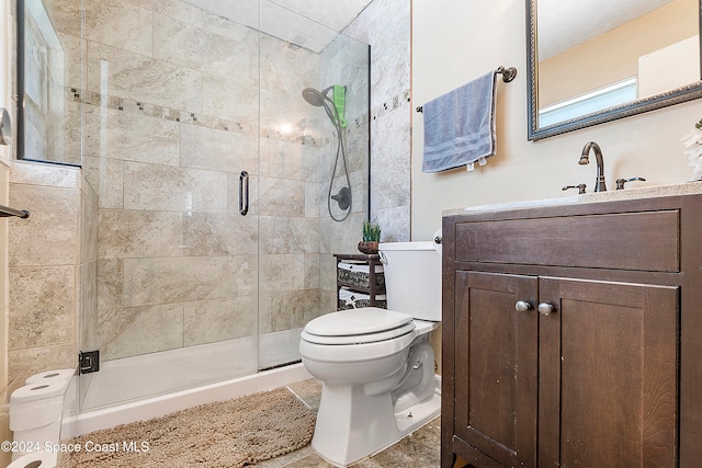 bathroom featuring vanity, toilet, and an enclosed shower