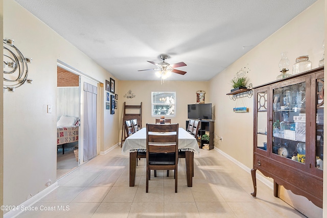 tiled dining area featuring ceiling fan and a textured ceiling