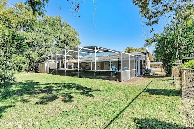 back of house featuring a yard and glass enclosure