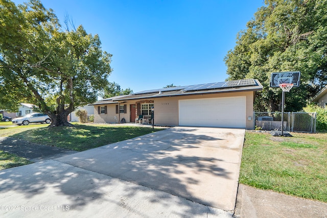 single story home featuring a front yard and solar panels