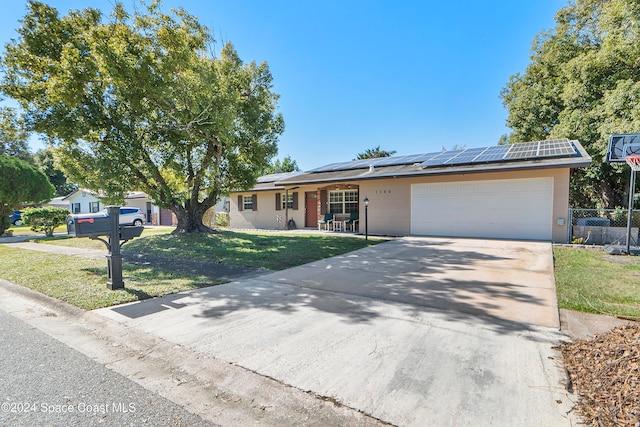 single story home featuring solar panels, a garage, and a front yard