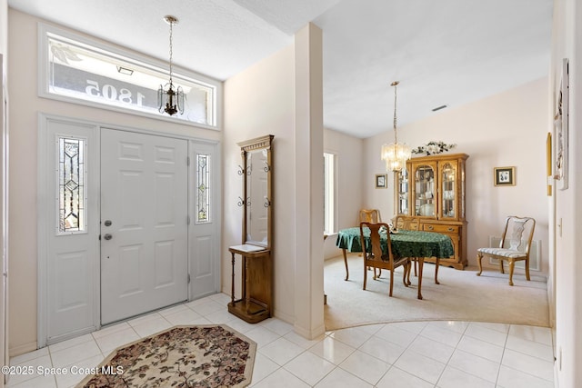 carpeted entryway with an inviting chandelier and lofted ceiling