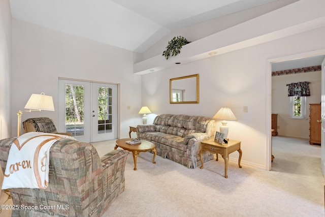 living room featuring lofted ceiling, a healthy amount of sunlight, light carpet, and french doors