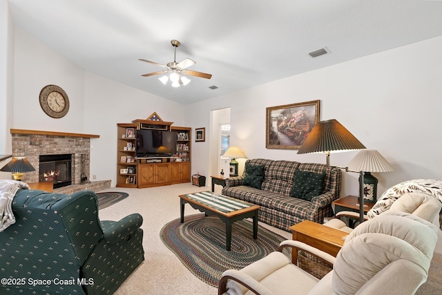 carpeted living room featuring vaulted ceiling, a brick fireplace, and ceiling fan