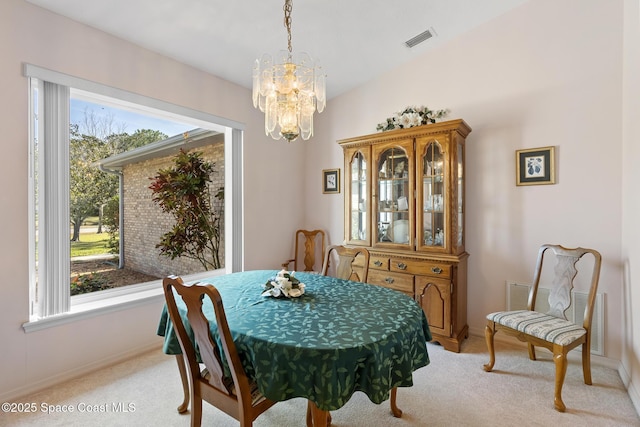 dining area featuring plenty of natural light, light carpet, and a notable chandelier