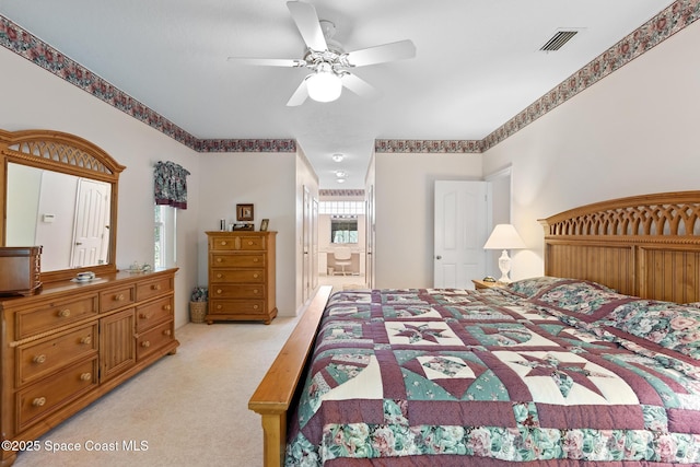 carpeted bedroom featuring ensuite bath and ceiling fan