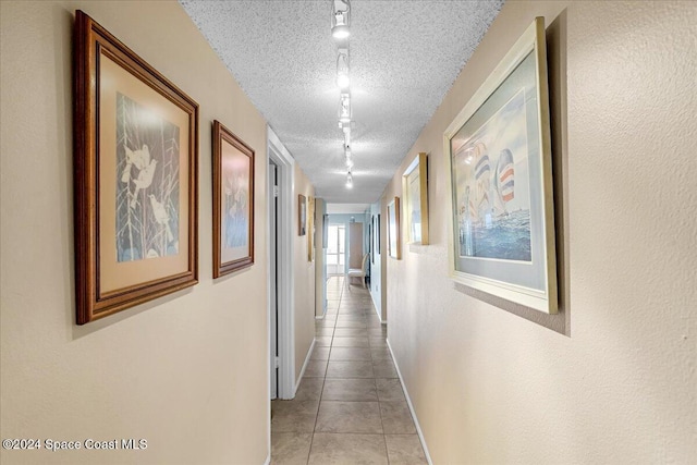 hall with light tile patterned floors and a textured ceiling