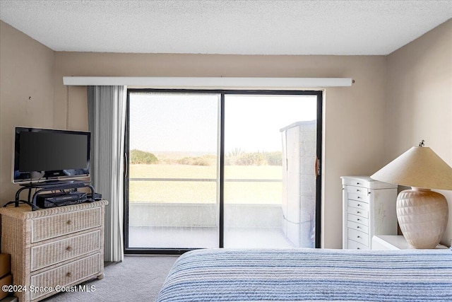 carpeted bedroom featuring access to outside and a textured ceiling