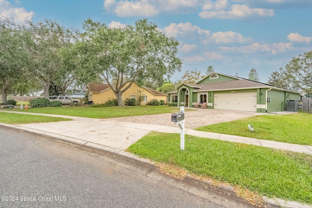 ranch-style house with a front yard, central AC unit, and a garage