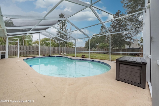 view of swimming pool with a lanai, a yard, and a patio