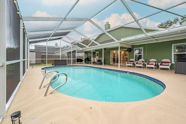 view of swimming pool featuring glass enclosure and a patio area