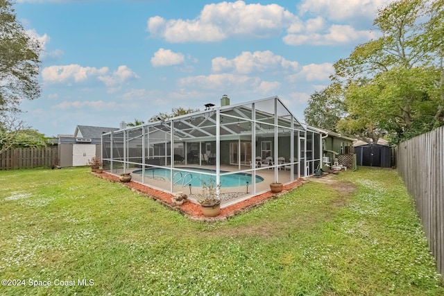 view of pool featuring a lanai, a lawn, and a shed