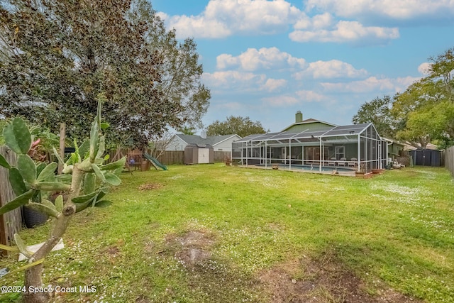 view of yard featuring glass enclosure, a shed, a playground, and a swimming pool