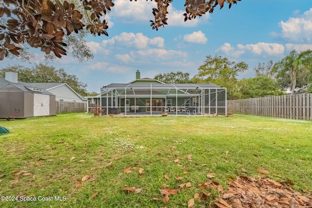 back of property featuring a lanai, a yard, and a shed