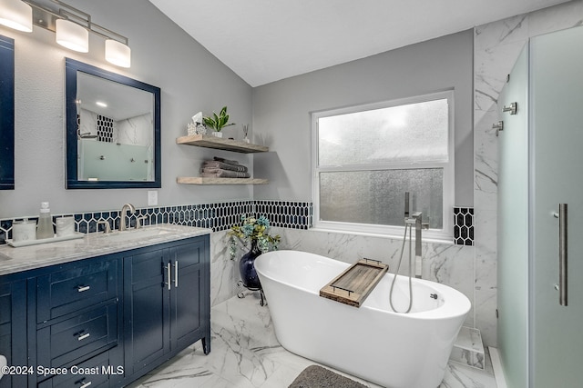 bathroom featuring plus walk in shower, vanity, and tile walls