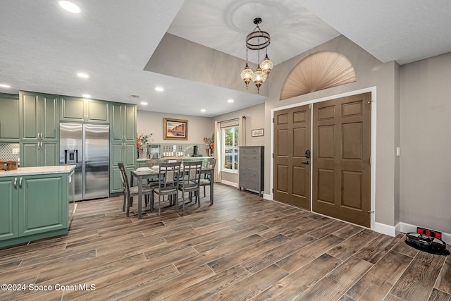 unfurnished dining area with wood-type flooring and a notable chandelier