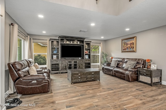 living room featuring wood-type flooring and a textured ceiling