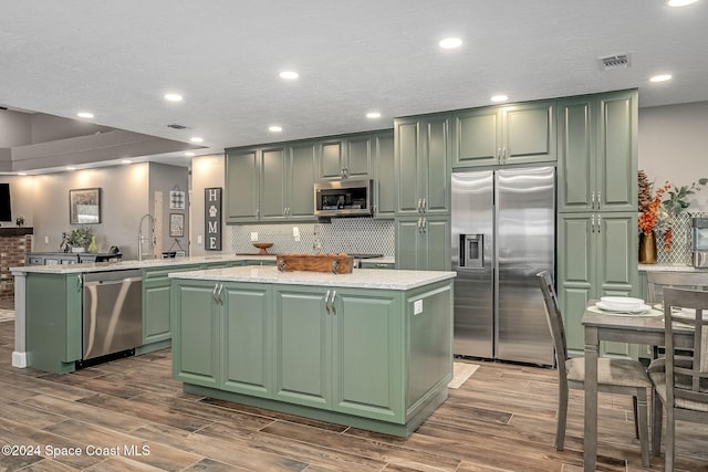 kitchen featuring appliances with stainless steel finishes, a kitchen island, and green cabinetry