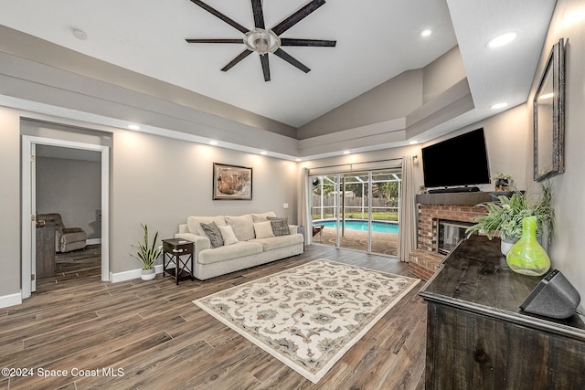 living room with a fireplace, dark hardwood / wood-style flooring, high vaulted ceiling, and ceiling fan