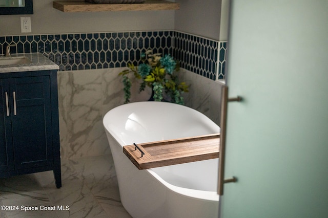 bathroom featuring vanity, tile walls, and a tub