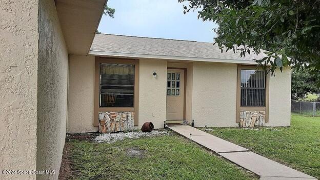 entrance to property with a lawn