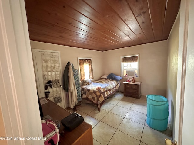 bedroom featuring cooling unit, wooden ceiling, and light tile patterned floors