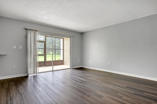 unfurnished room with dark wood-type flooring and a textured ceiling