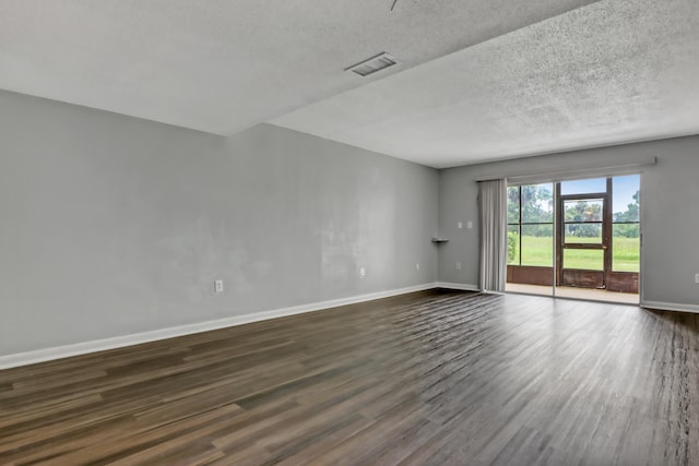 spare room featuring dark hardwood / wood-style flooring and a textured ceiling