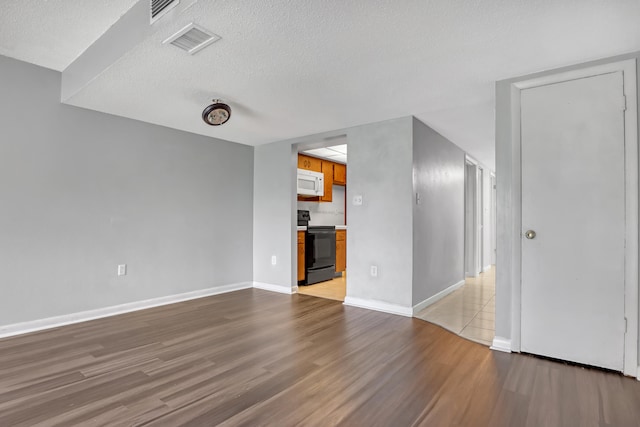 unfurnished living room with light hardwood / wood-style floors and a textured ceiling