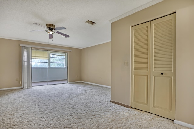 unfurnished bedroom featuring access to exterior, ceiling fan, crown molding, light colored carpet, and a textured ceiling