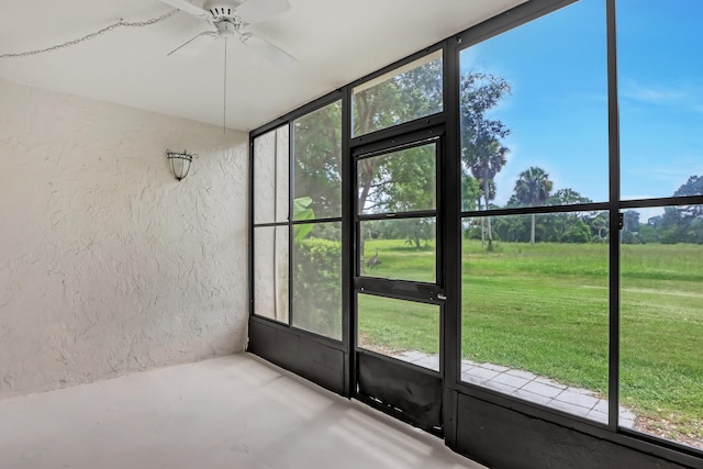 unfurnished sunroom with ceiling fan