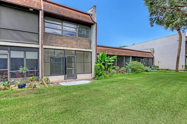 rear view of property featuring a lawn