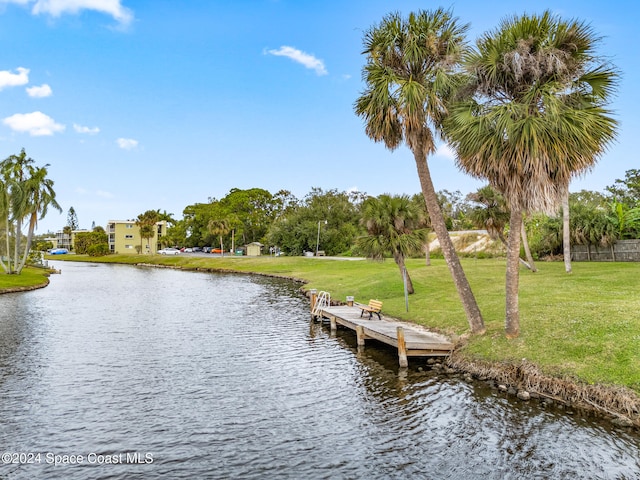 dock area featuring a water view and a lawn