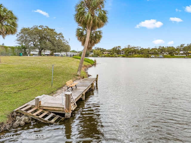 dock area with a water view and a yard