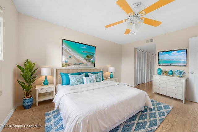 bedroom with ceiling fan, light hardwood / wood-style floors, and a closet