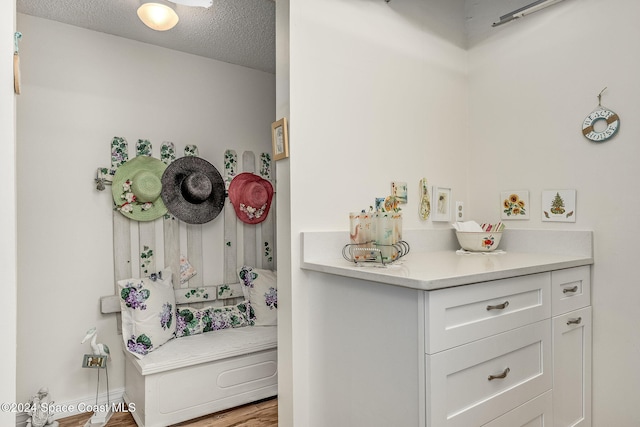 bathroom with hardwood / wood-style flooring, vanity, and a textured ceiling