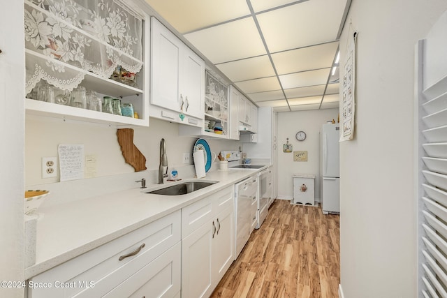 kitchen with white cabinetry, sink, light hardwood / wood-style flooring, white appliances, and a paneled ceiling