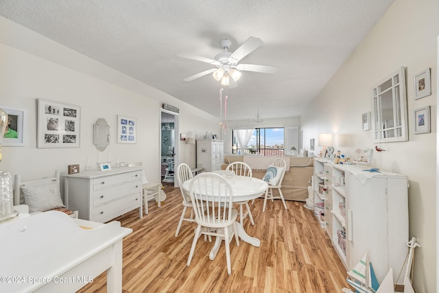 dining area featuring ceiling fan, light wood-type flooring, and a textured ceiling