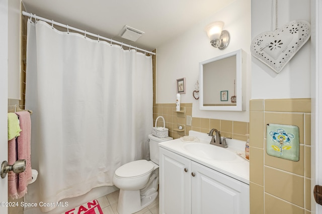 bathroom with curtained shower, tile patterned floors, toilet, vanity, and tile walls