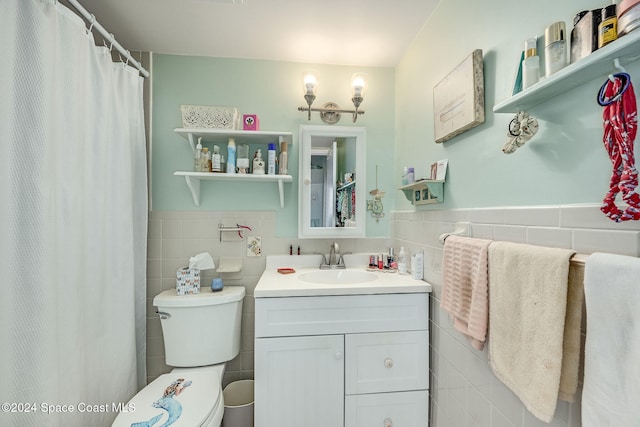 bathroom with vanity, tile walls, and toilet