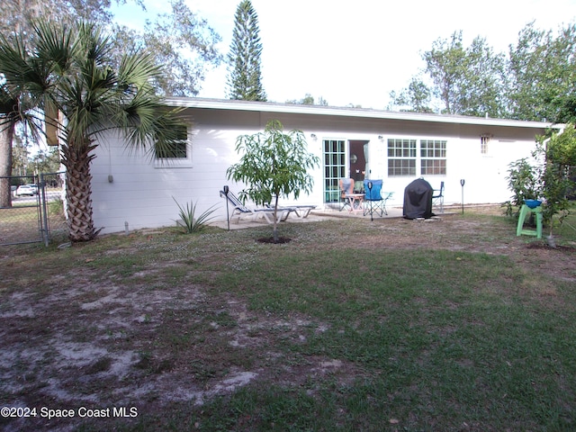 back of house featuring a lawn