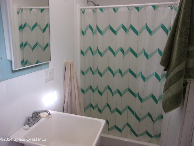 bathroom featuring sink and tile walls