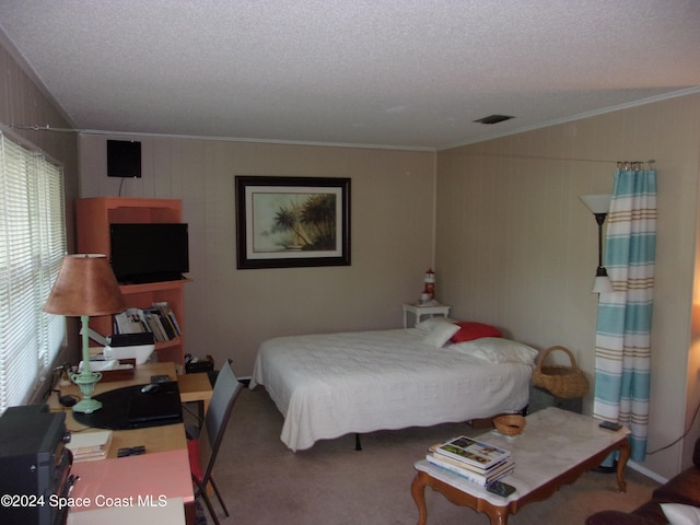 bedroom with carpet, ornamental molding, and a textured ceiling