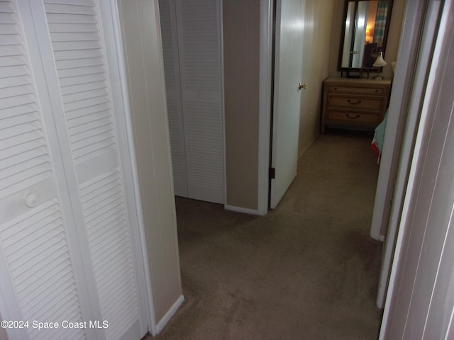 hallway featuring dark colored carpet