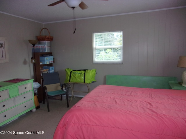 carpeted bedroom featuring ceiling fan and crown molding